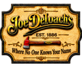 A decorative vintage-style sign for 'Joe Deloach's' with the tagline 'Where No One Knows Your Name', featuring a small axe illustration and 'EST. 1886' text on a distressed tan background with a dark border.