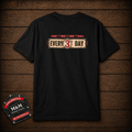 A black short-sleeve t-shirt displayed flat against a dark brown wood plank background. The shirt features a distressed graphic on the chest that reads 'EVERY 3RD DAY' in red, beige, and black.