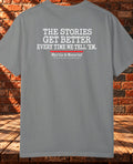 Back view: Gray T-shirt with “The Stories Get Better Every Time We Tell ’Em” in white lettering, a red underline, and Myrtle & Moncrief branding.