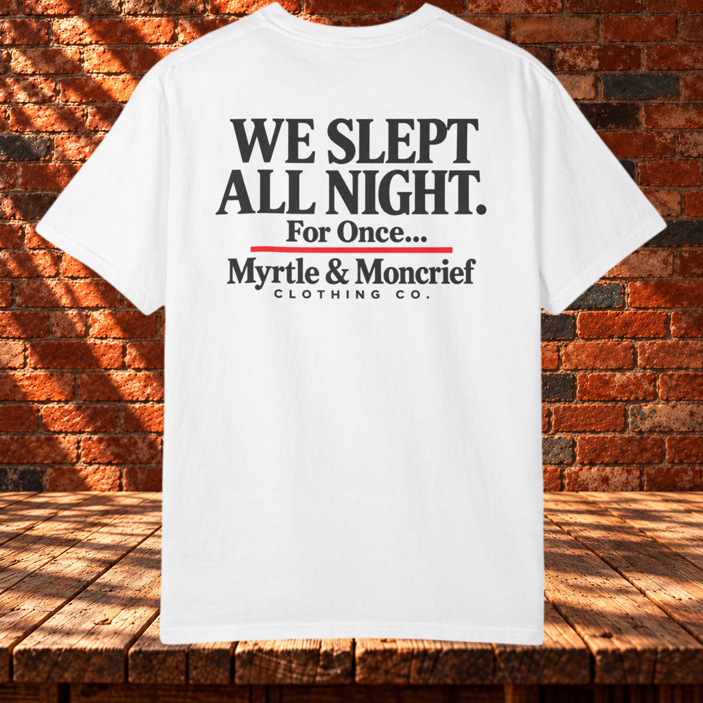 Back view: White T-shirt with “We Slept All Night. For Once...” in black, a red underline, and Myrtle & Moncrief Clothing Co. branding.